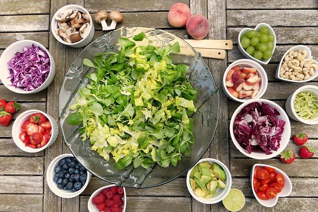 Schüsseln mit Salat und verschiedenen Obst- und Rohkostsorten